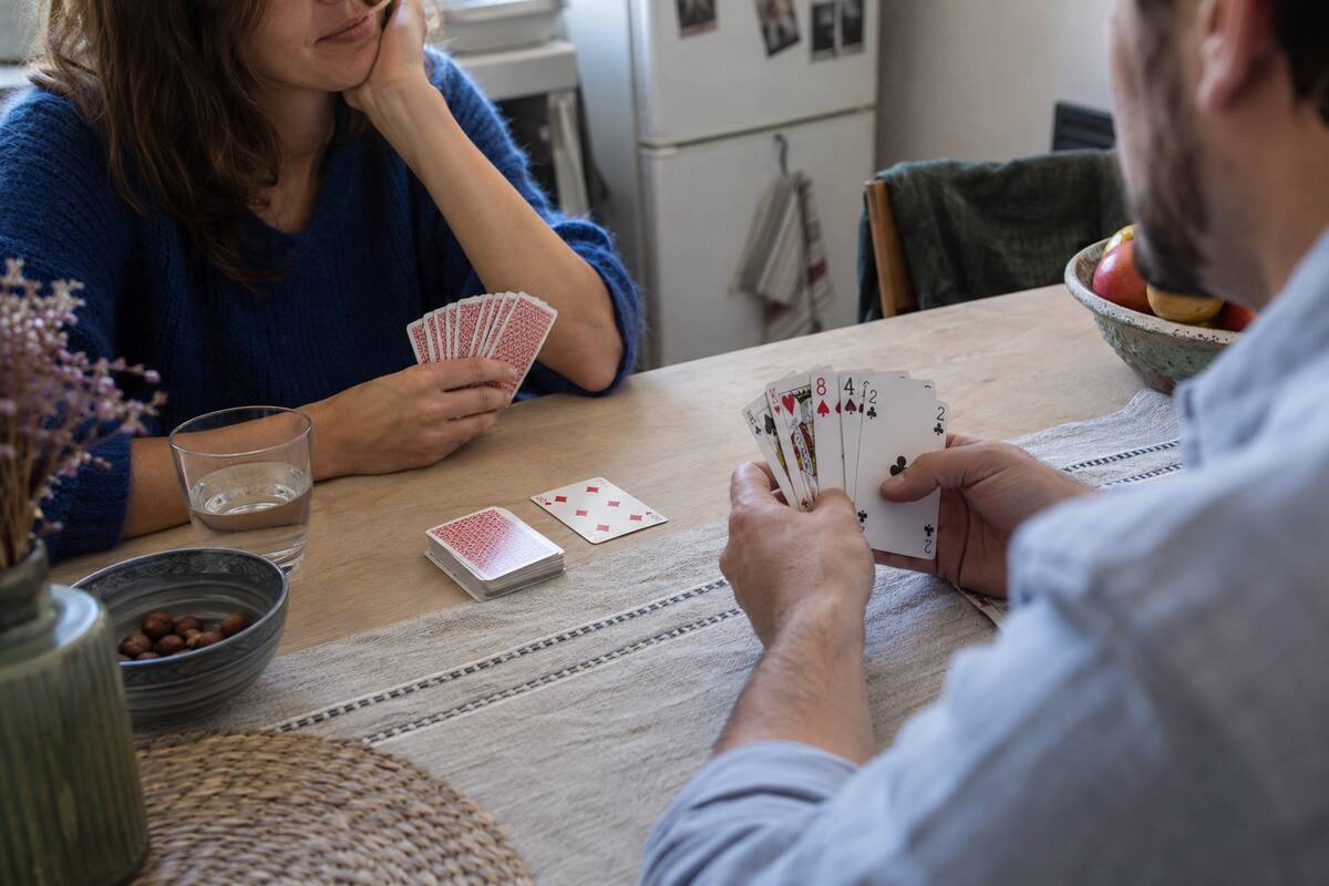 Deux personnes sont assises à une table et jouent aux cartes